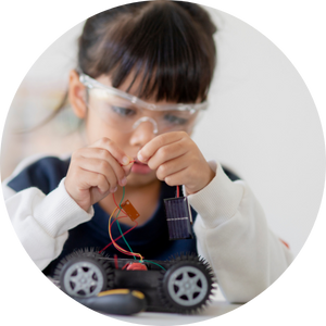  young girl connecting wires on robotic car